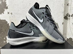 Pair of black and grey low-top shoes displayed at an angle, showing the side logos, patterned panels, and white midsoles.
