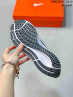 Close view of the sneaker outsole showing a segmented patterned tread with dark rubber sections and a white midsole.