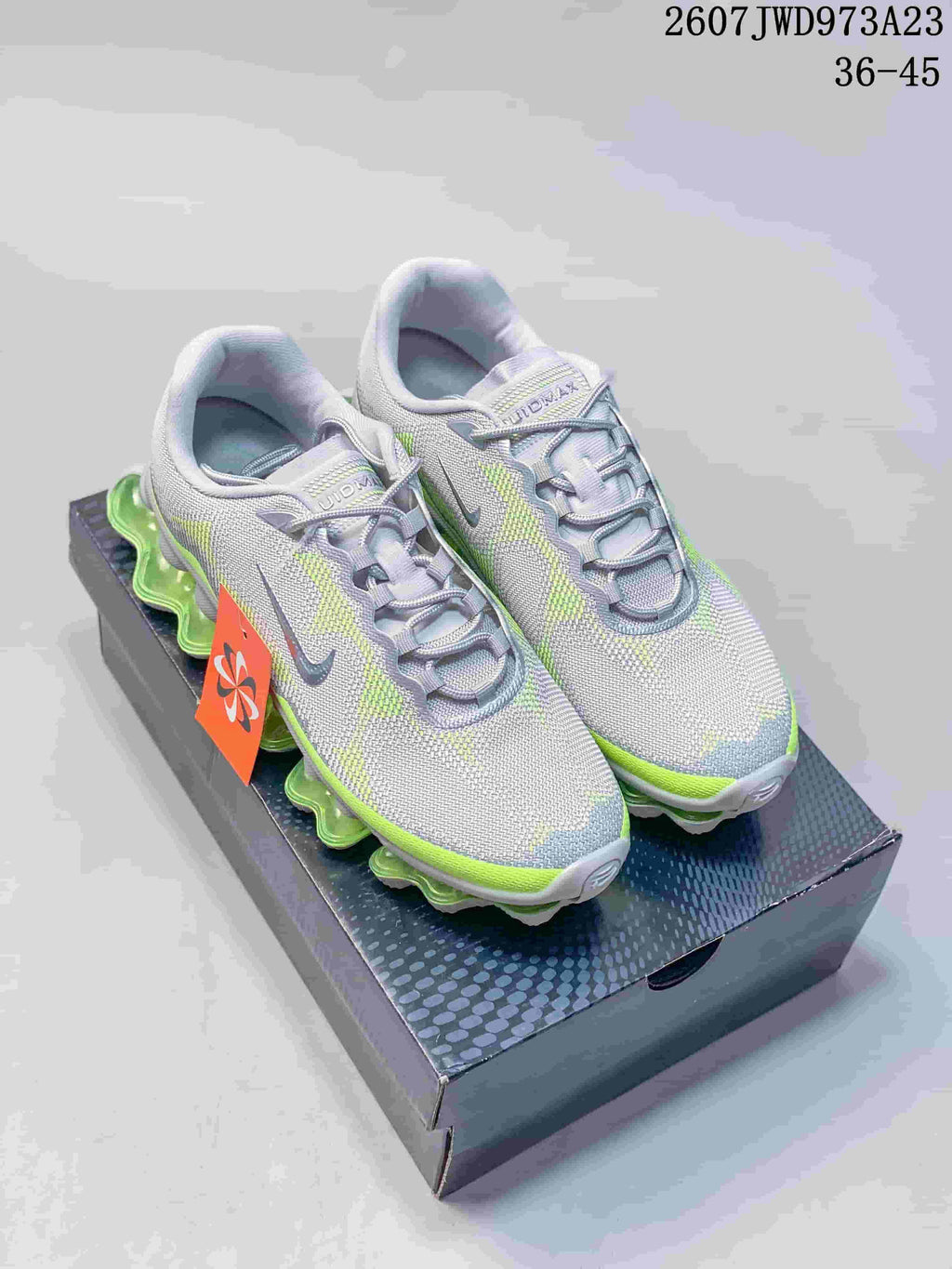 Pair of gray and neon green Nike Air Liquid Max sneakers displayed on a shoebox.