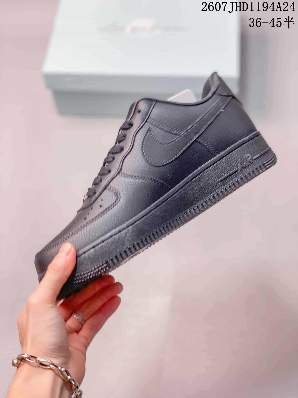 Side profile of a black Nike Air Force 1 '07 sneaker showing the tonal Swoosh, layered panels and low rubber sole.