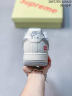 Rear view of a white sneaker showing the Nike Air logo on the heel tab, a Supreme logo accent, and a grey outsole.