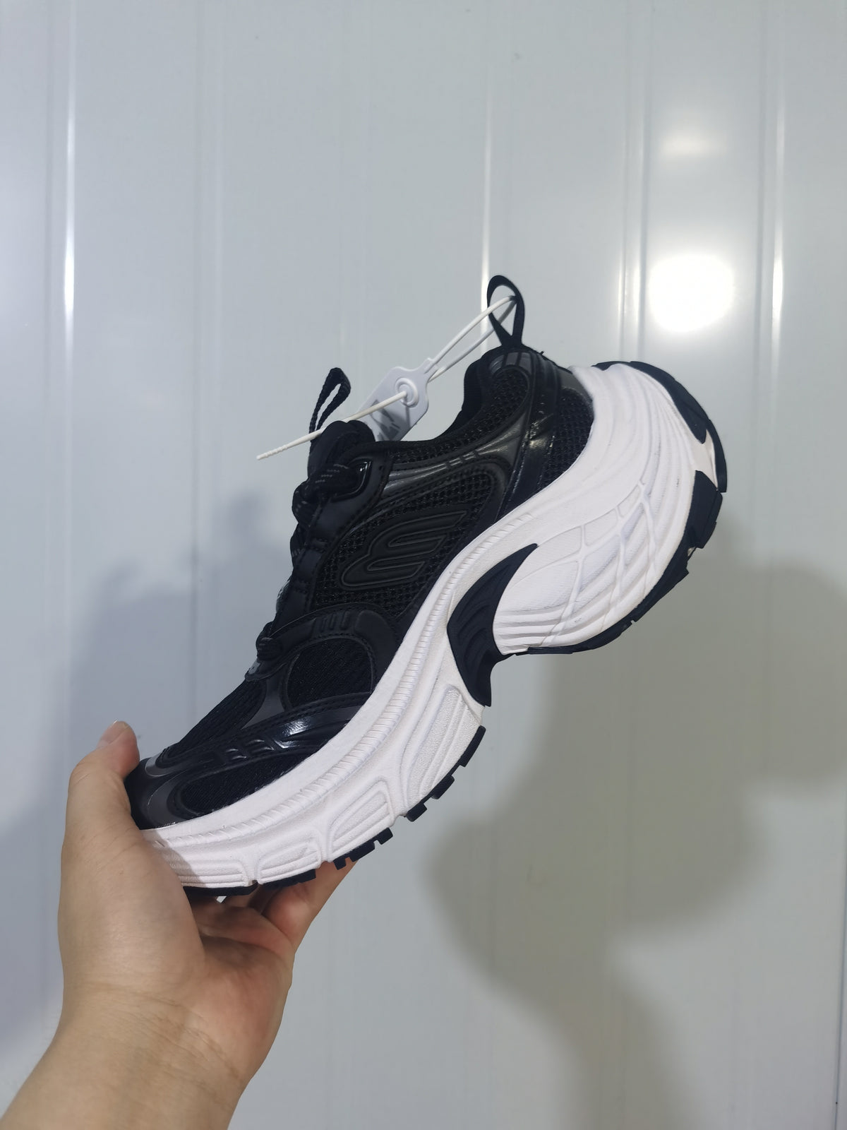 Black and white Skechers sneaker shown from the opposite side with mesh-look panels and contrasting outsole.