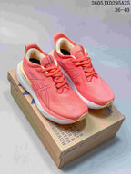 Pair of coral-pink ASICS GEL-CUMULUS 26 shoes displayed on a shoebox