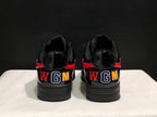 Rear view of the black sneakers showing multicolor WGM lettering and red heel accents.