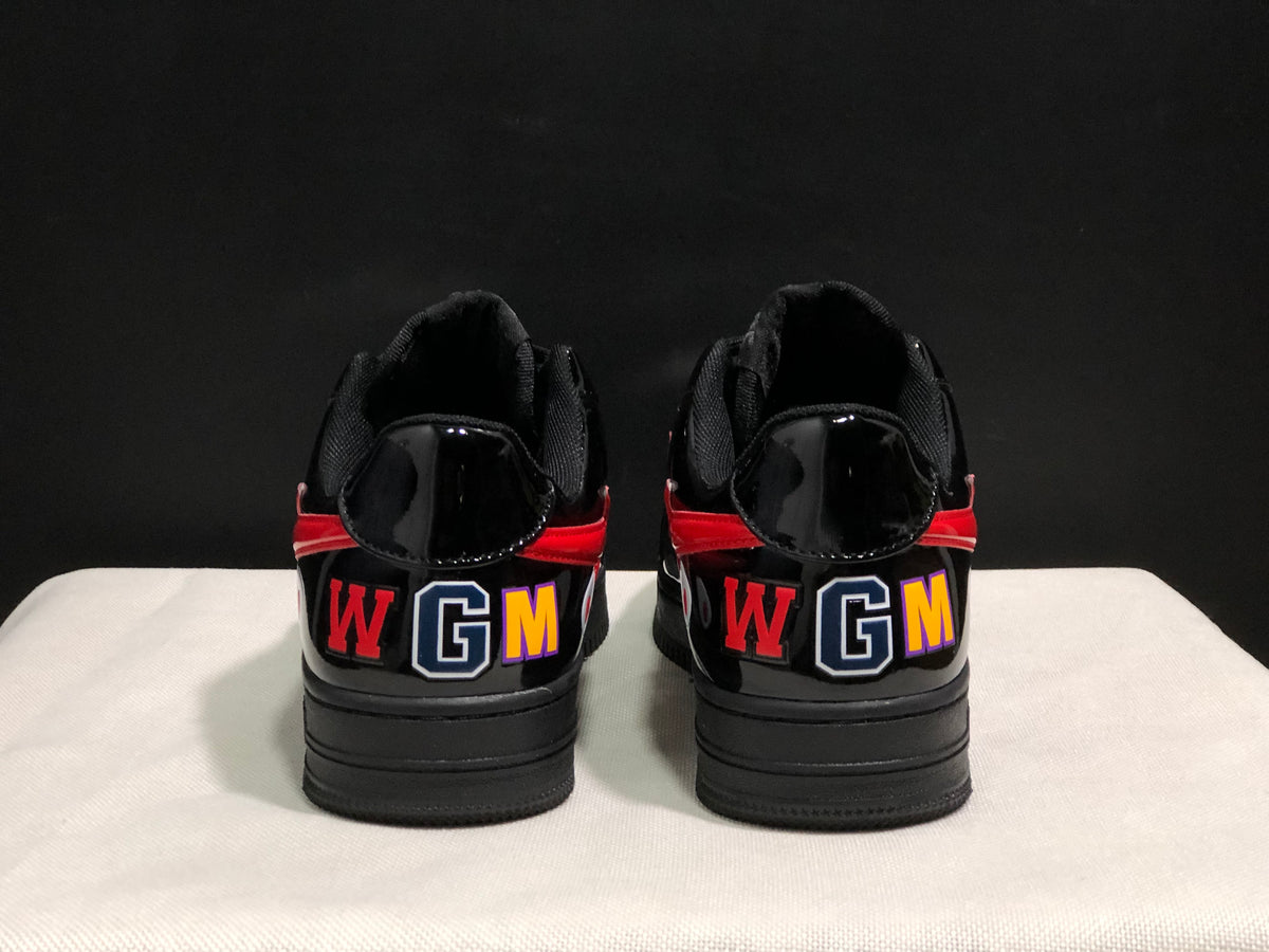Rear view of the black sneakers showing multicolor WGM lettering and red heel accents.