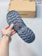 Close-up of the black lugged outsole showing its deep multi-directional tread pattern.