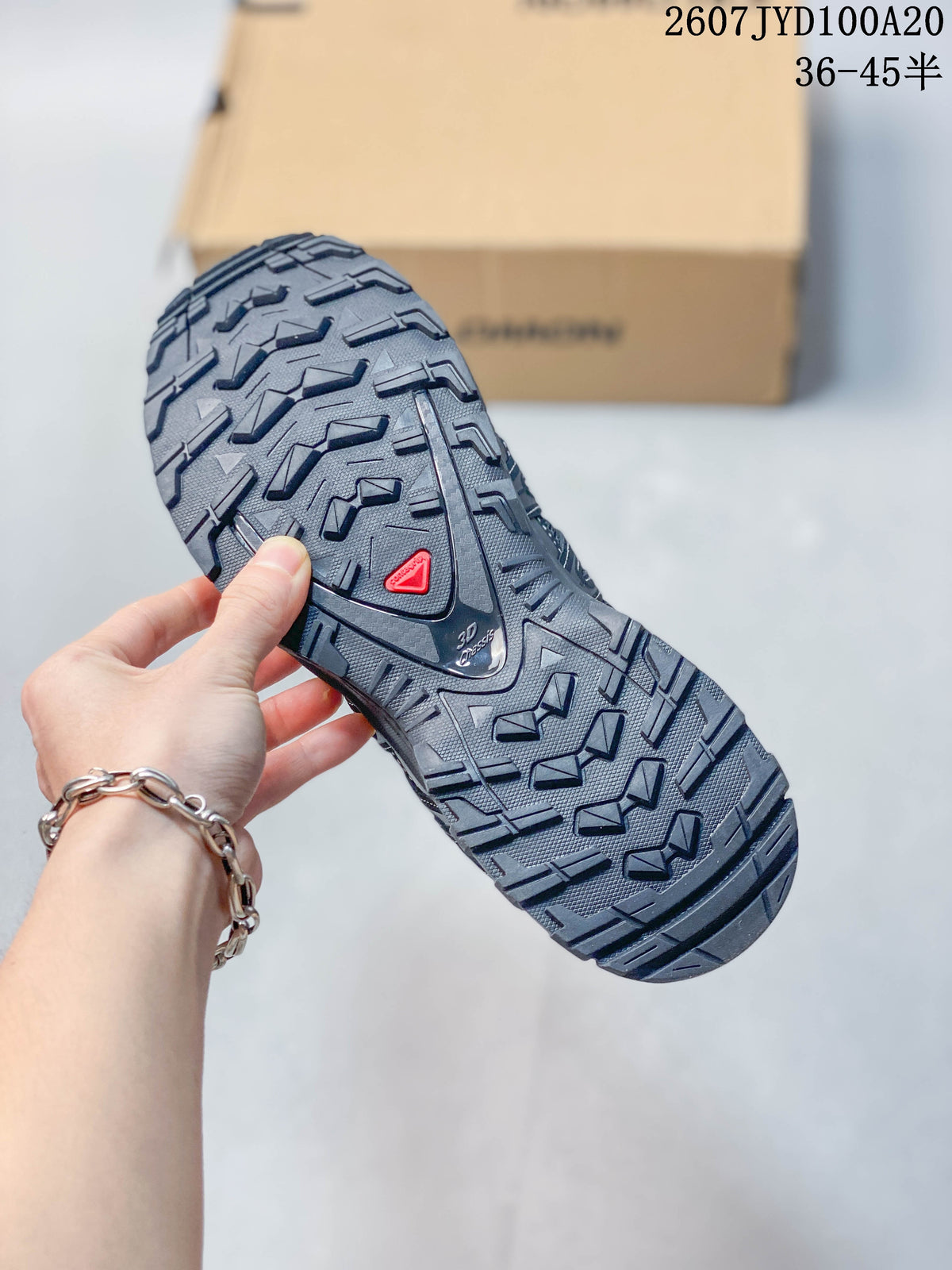 Close-up of the black lugged outsole showing its deep multi-directional tread pattern.