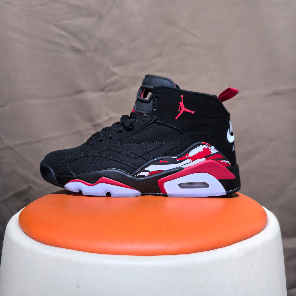 Side view of a black high-top sneaker with red detailing and visible heel unit