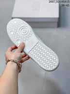 Underside of a white sneaker showing the textured rubber outsole