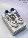 Pair of white and brown plaid Nike SB Dunk Low sneakers displayed on a patterned shoebox.