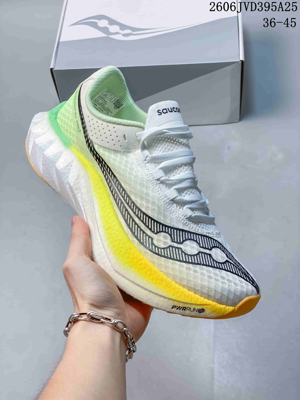White Saucony running shoe with yellow and green accents, shown in close-up; image text states 36–45.