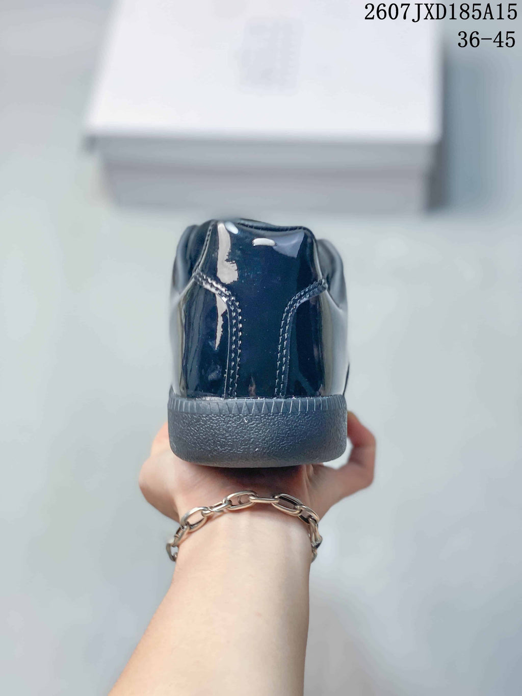 Rear view showing the glossy heel panels, stitching and textured rubber sole.