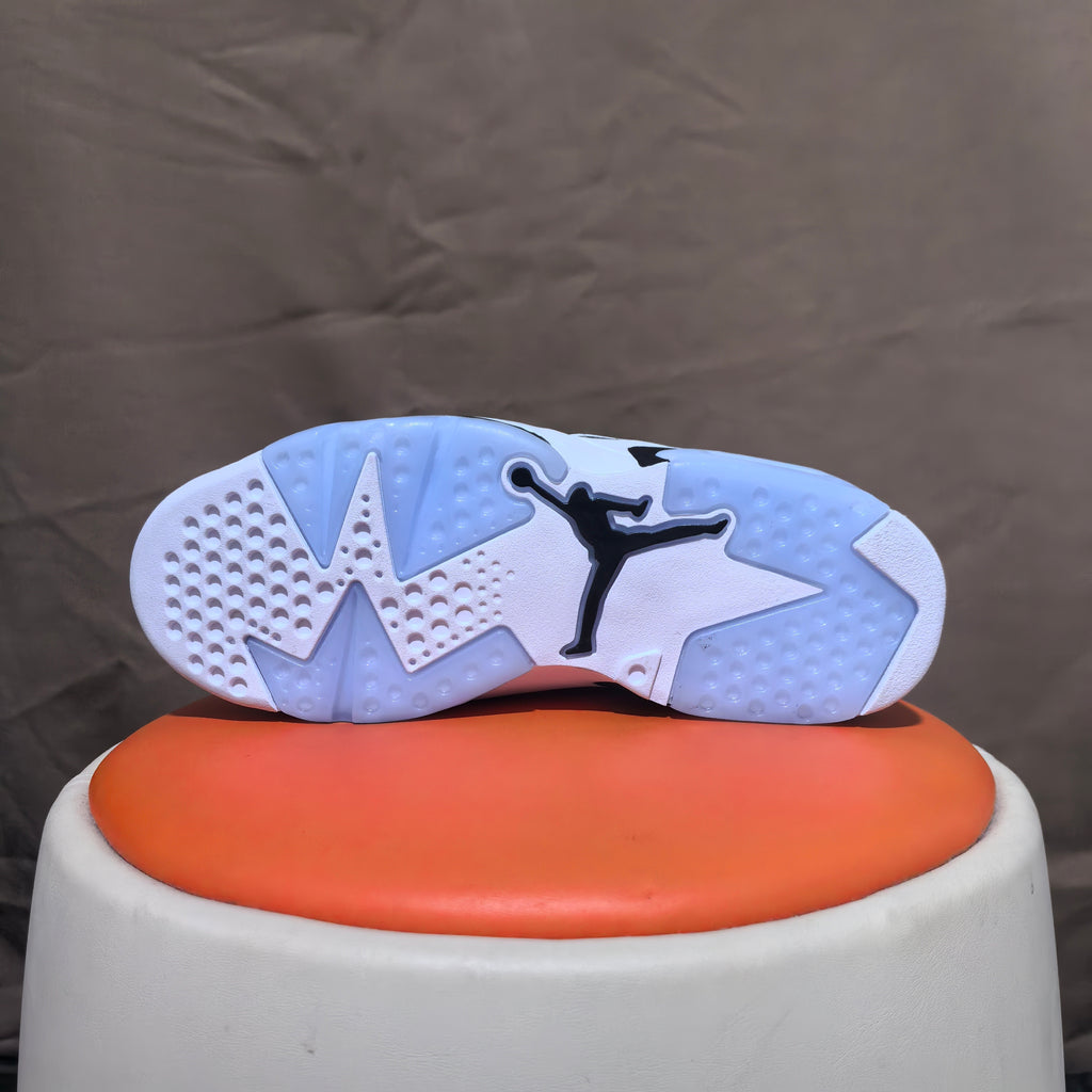 Underside of a white sneaker with black Jumpman detail and segmented tread.