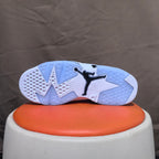 Underside of a white sneaker with black Jumpman detail and segmented tread.