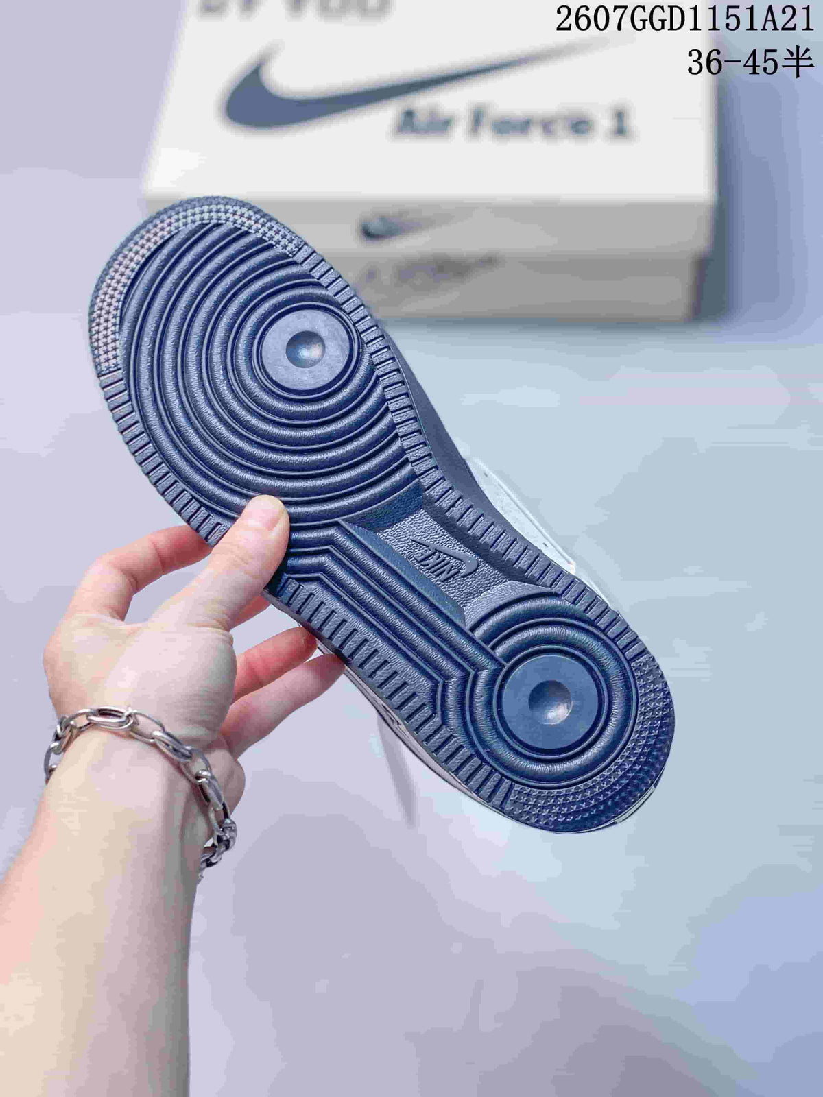 Close-up of the navy rubber outsole showing concentric circular traction grooves and textured edges.