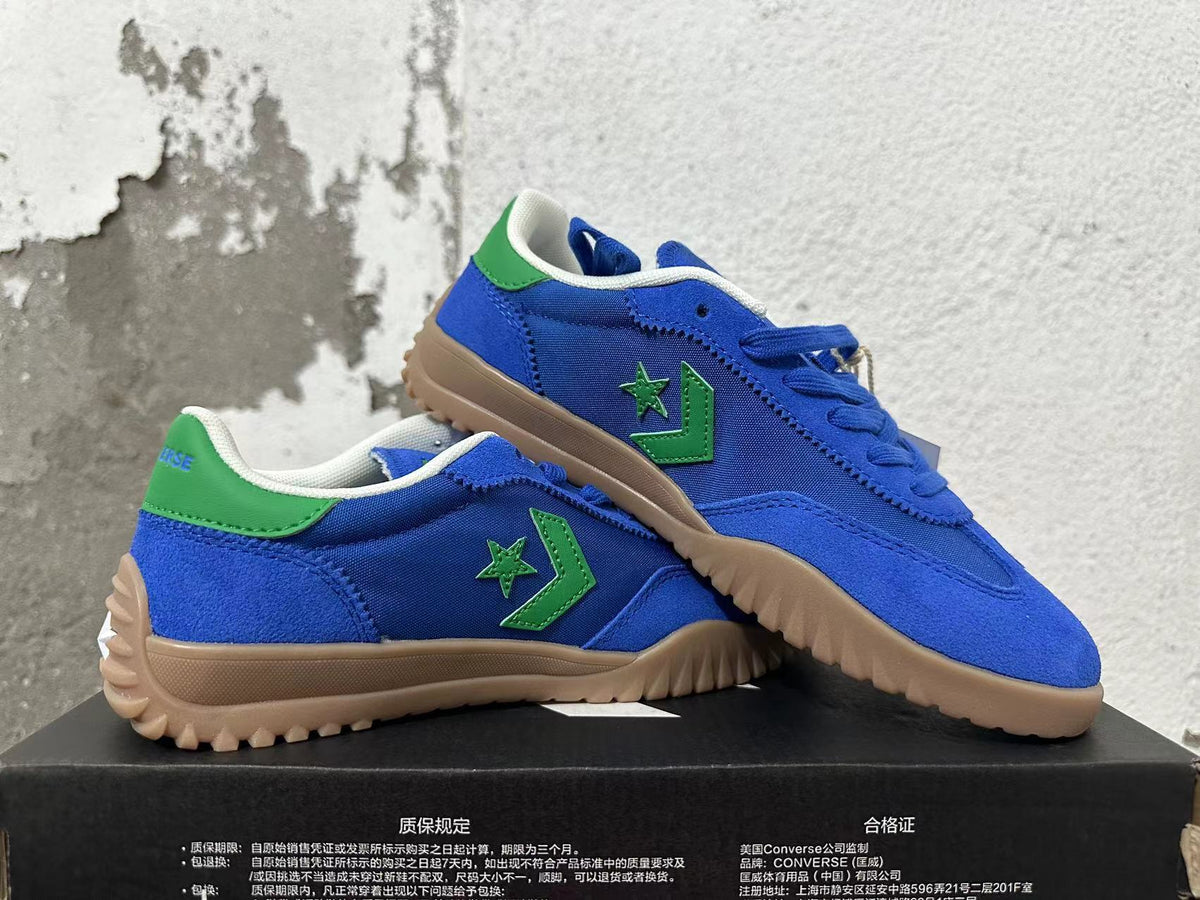 Pair of blue Converse shoes with green accents and textured gum-colored outsoles