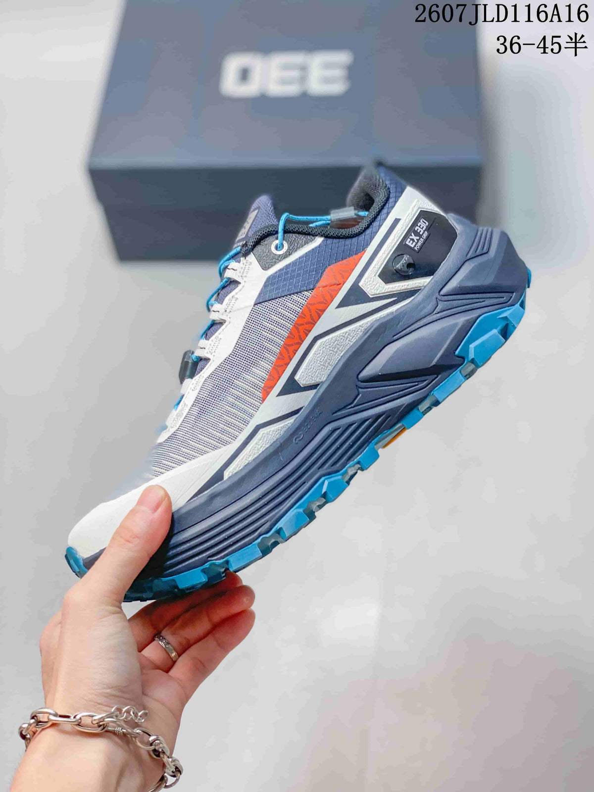 Side view of the trail shoe showing the gray mesh-style upper, white overlays, orange accent, and blue outsole lugs.