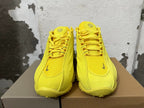 Front view of yellow lace-up sneakers with sculpted panels.