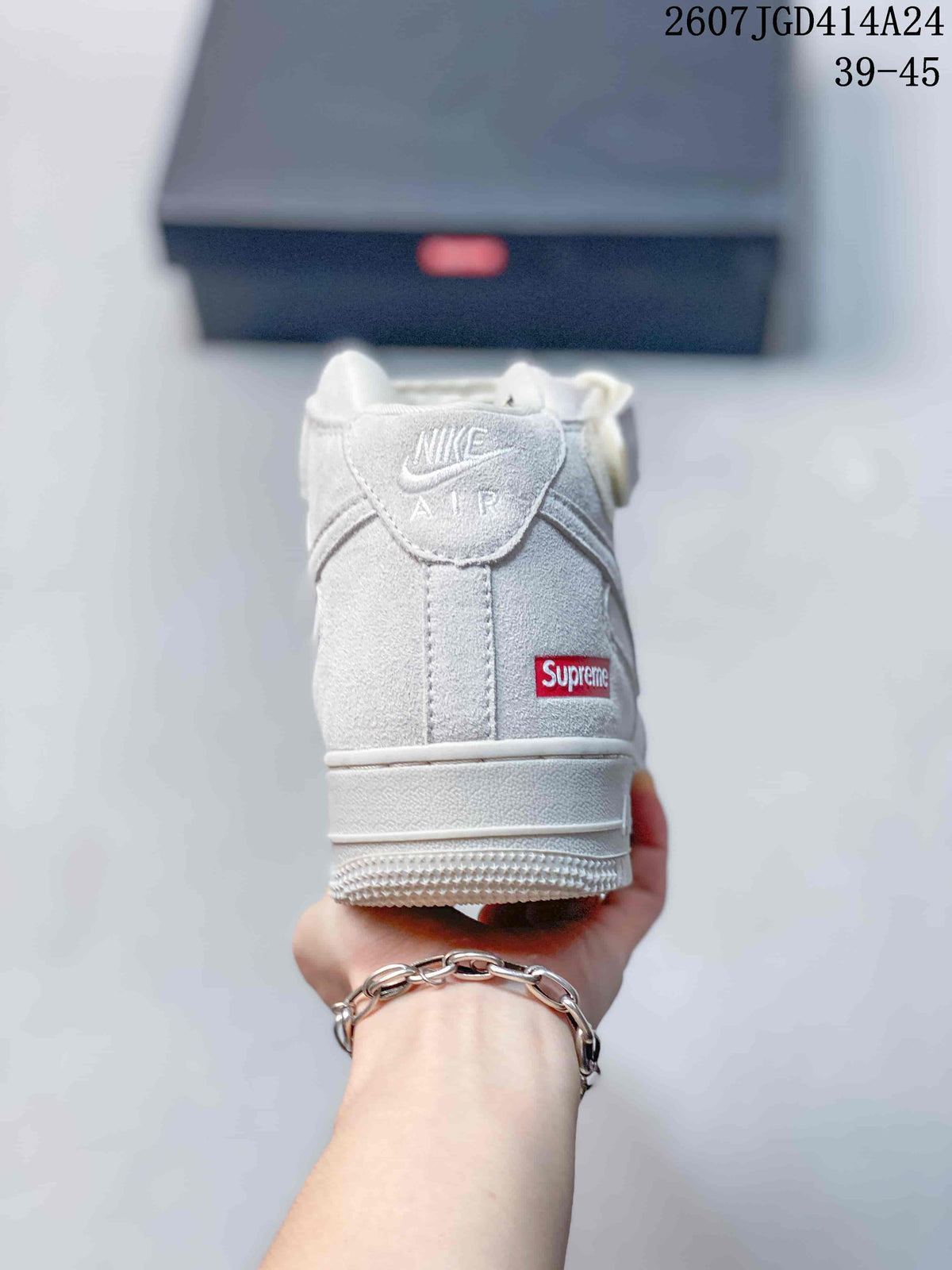 Rear view of a white mid-top sneaker showing the ankle strap, heel tab, raised sole, and red heel label.