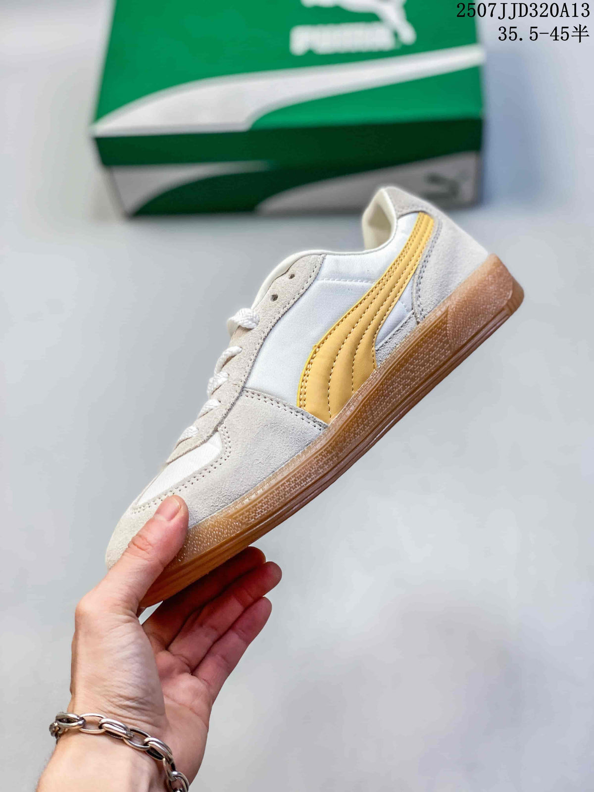 Side profile showing the white and yellow upper, layered panels, and gum-colored sole.