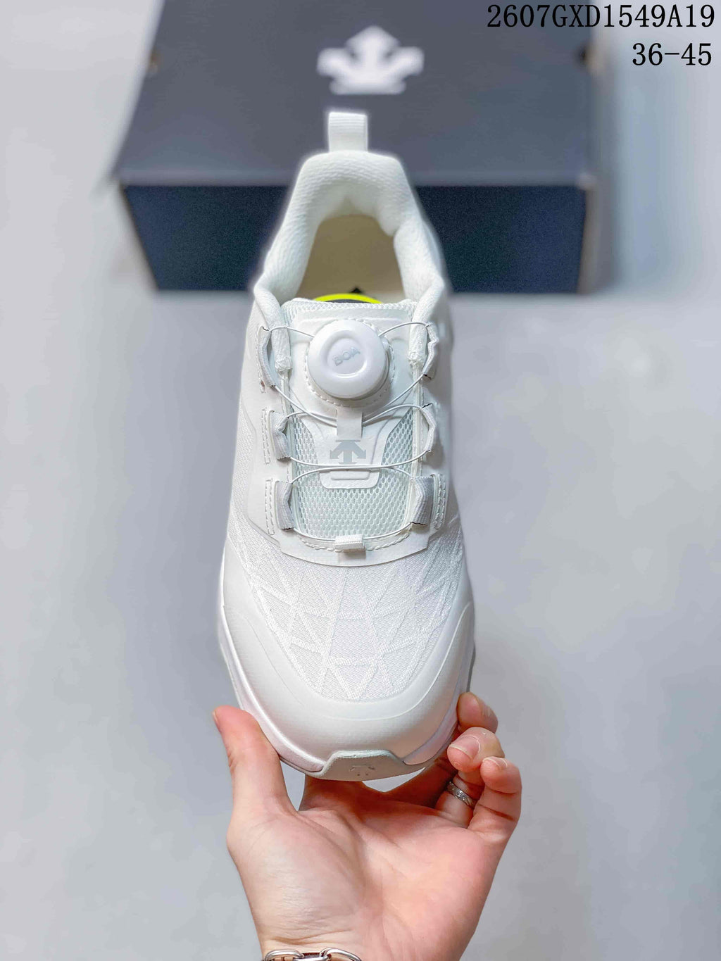 Top view of the white sneaker showing the dial closure, wire-style fastening, and textured forefoot.