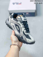 Angled side view of a black-and-white FILA Pebble sneaker showing the FILA side logo, layered detailing, and rugged textured outsole; overlay shows style code 2607JWD765A15 and size range 35.5–40.5.