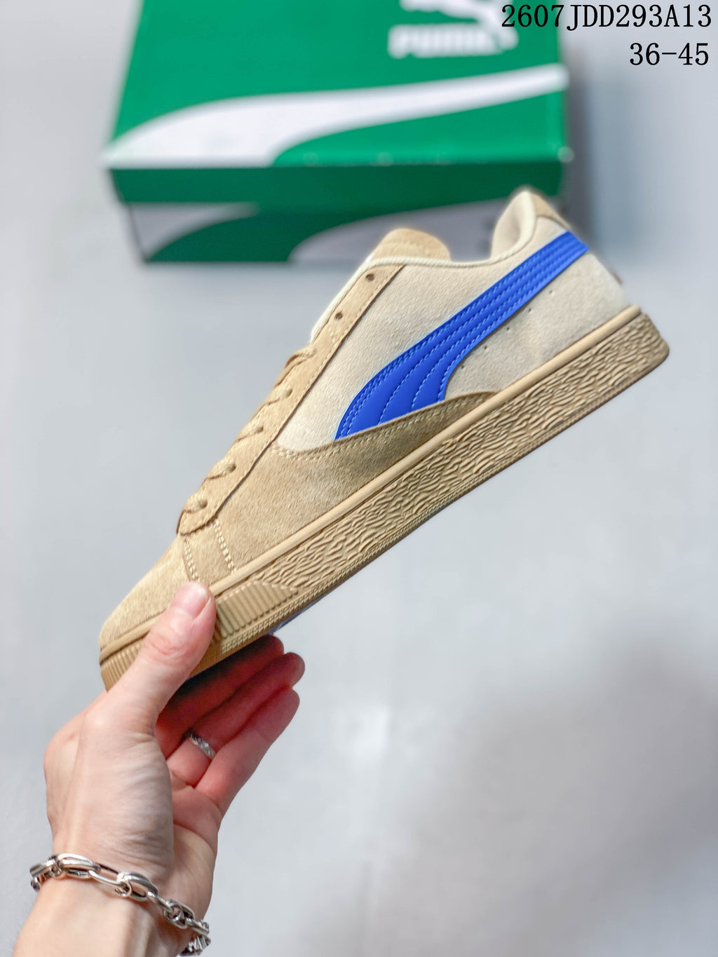 Side profile of the tan sneaker with a blue PUMA side stripe and textured outsole.