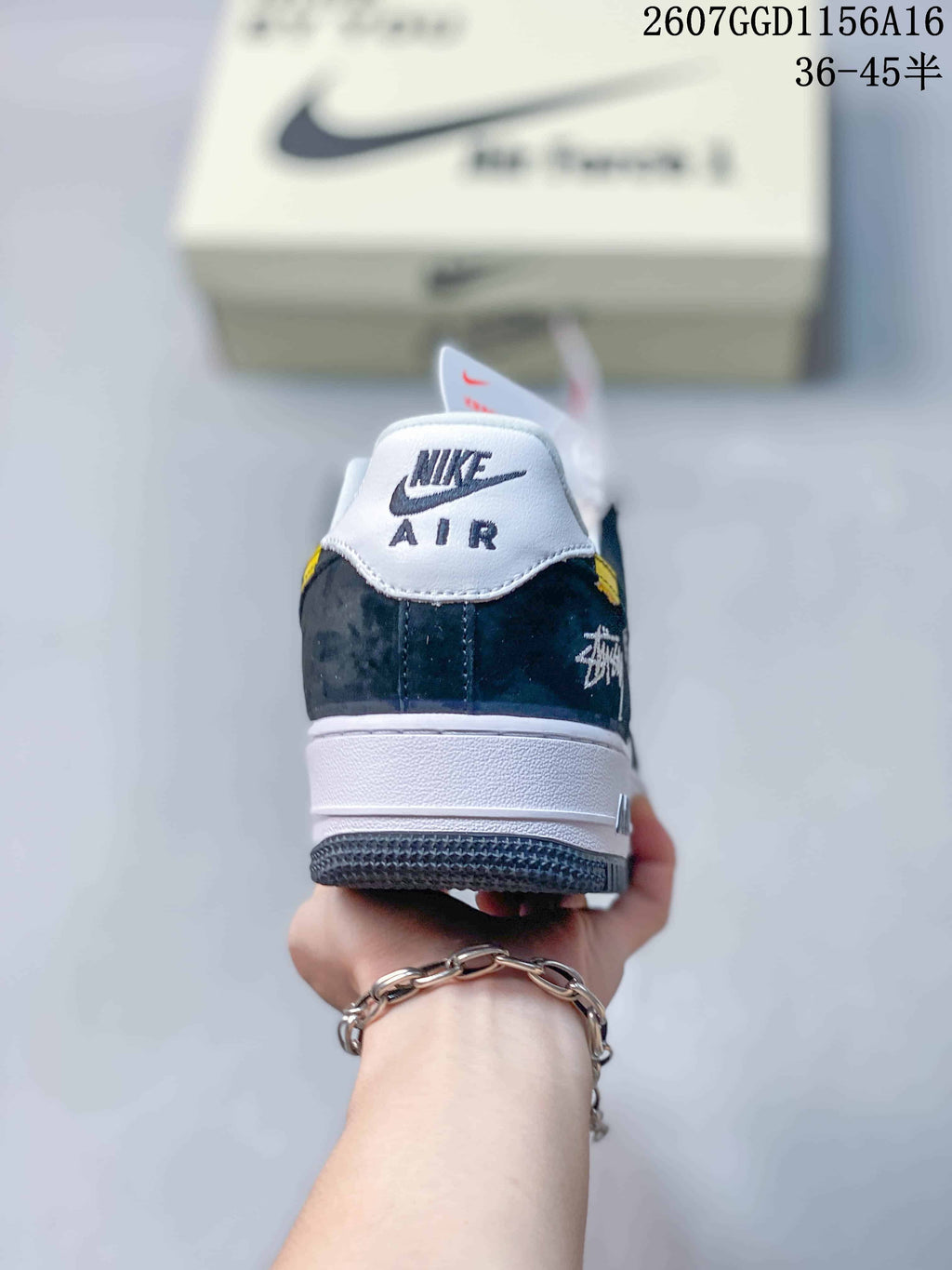 Rear view of the sneaker showing the white padded collar, Nike Air branding, dark heel panel, and signature-style side graphic.