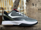 Side view of black and white Nike Kobe 6 basketball shoe with red accents