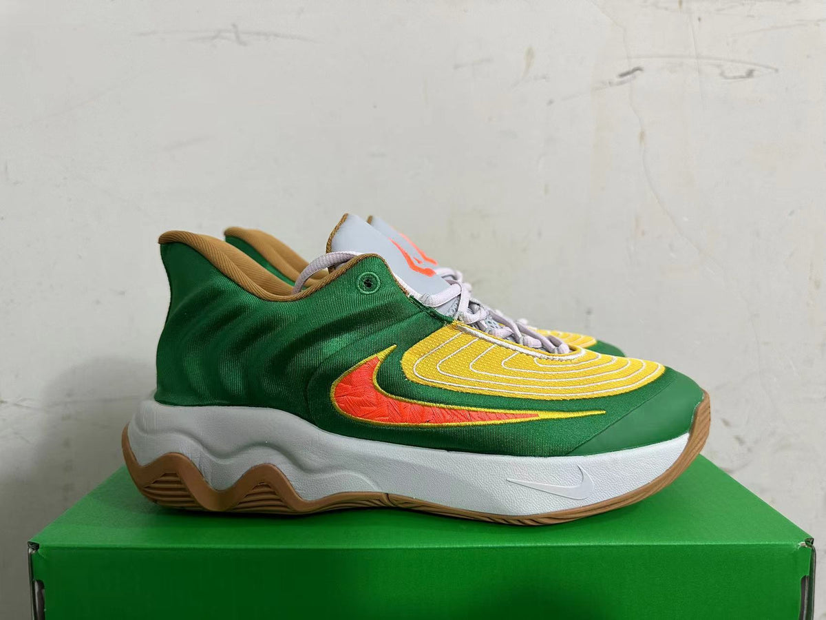 Side view of a green and yellow Nike basketball shoe with an orange Swoosh and gum outsole.