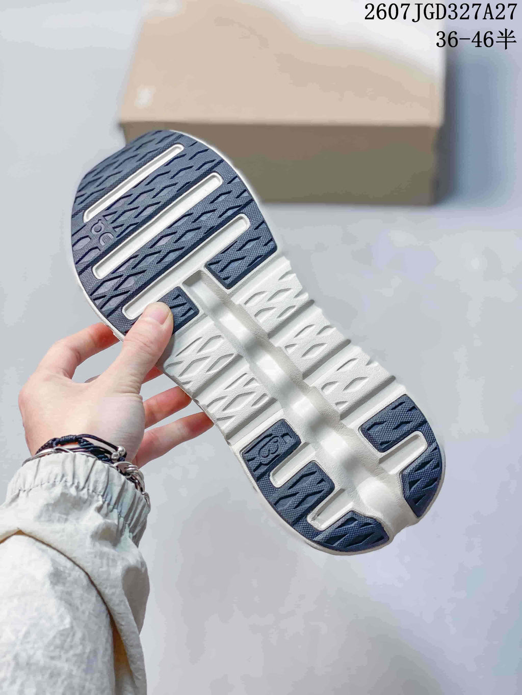 Close view of the sneaker outsole showing blue-gray traction sections and recessed channels.