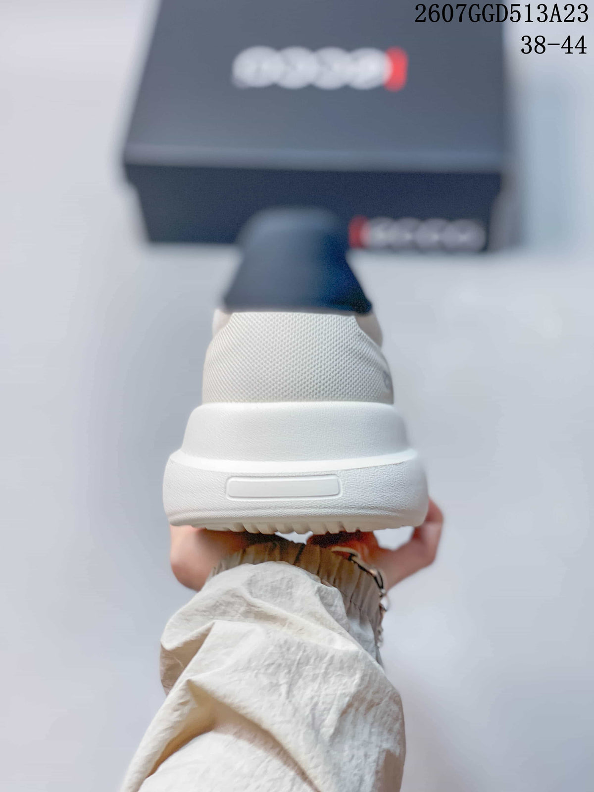 Rear view of the light gray sneaker showing the padded heel collar and raised white outsole.