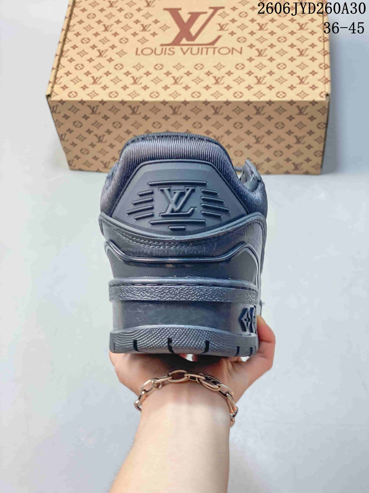 Rear view of the charcoal sneaker with a raised logo on the heel