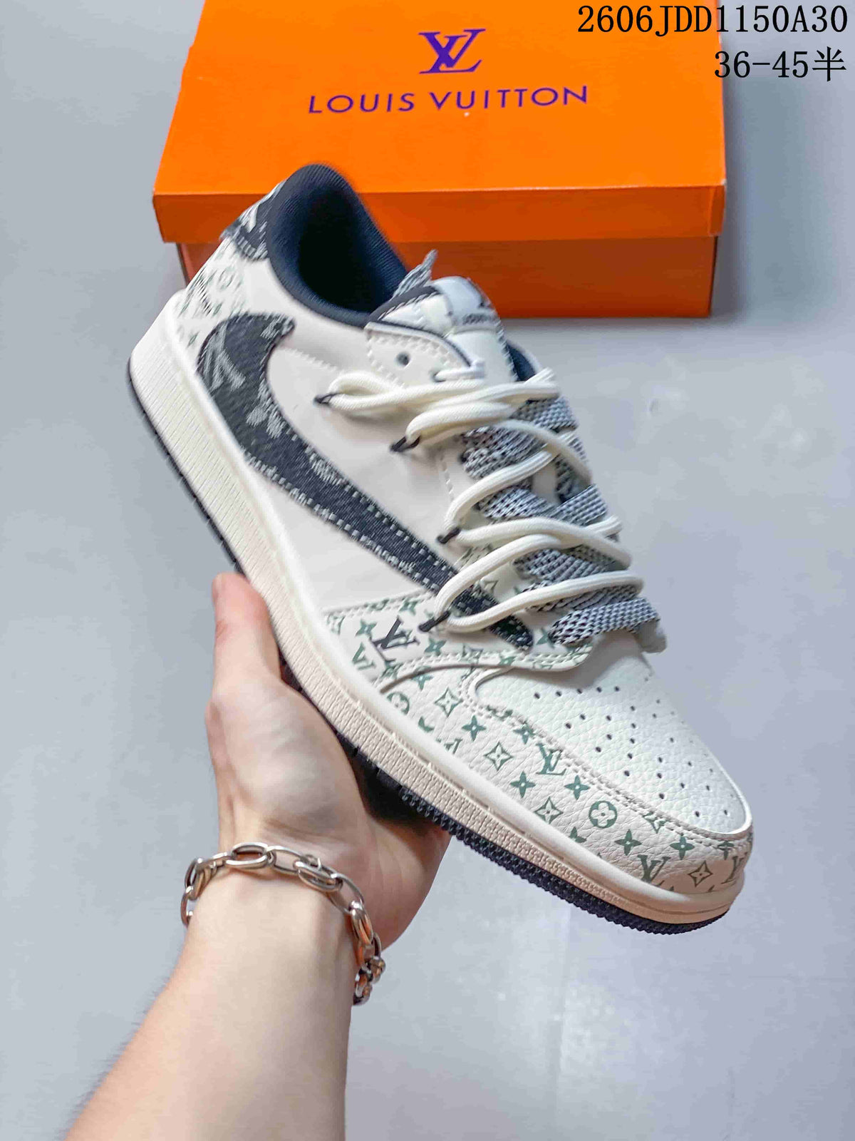 Hand-held side view of a white low-top sneaker with patterned toe and heel sections.