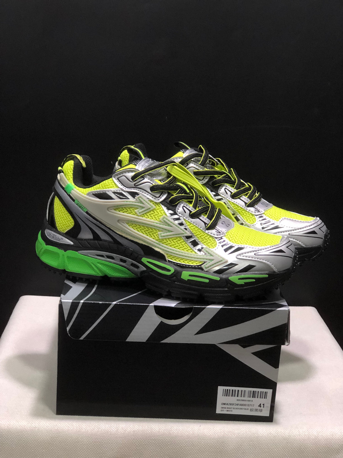 Pair of neon green, black, white, and silver Off-White sneakers displayed on a branded shoe box; the box label shows size 41.