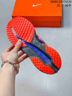Underside of a running shoe showing orange tread and a blue center outsole panel