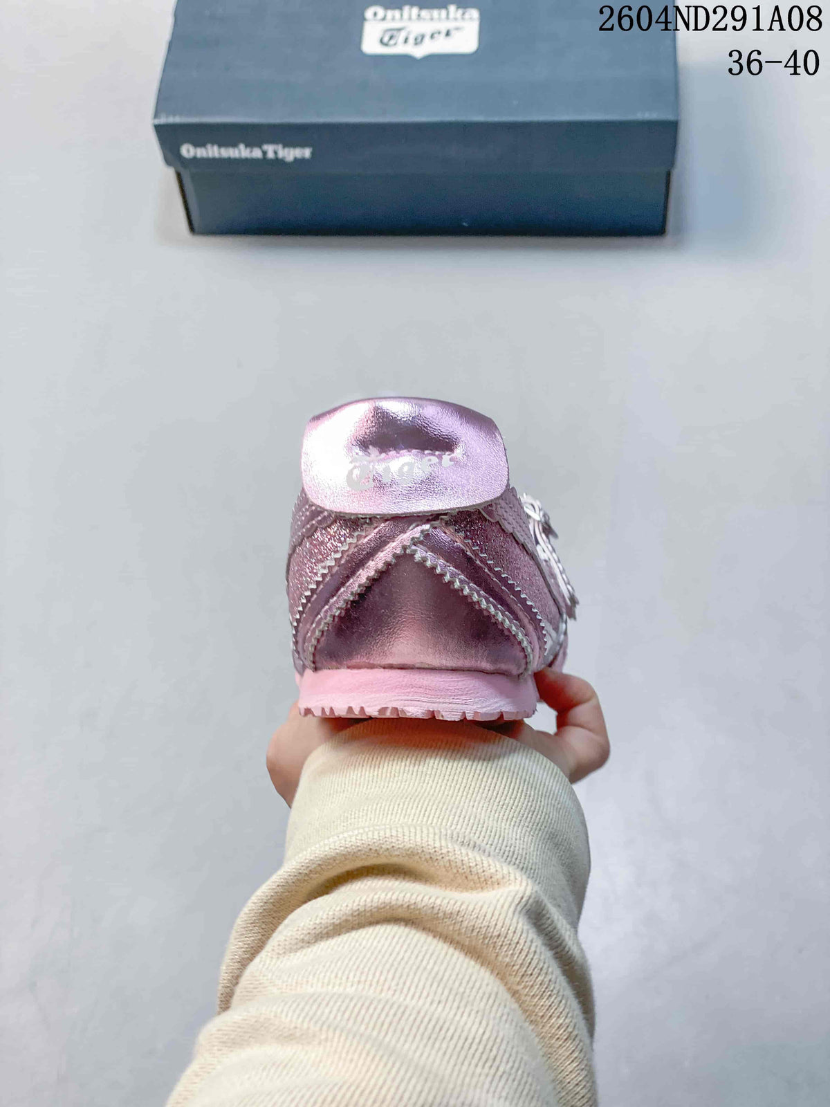 Rear view of the pink sneaker showing the heel construction, layered side panels, and textured outsole.