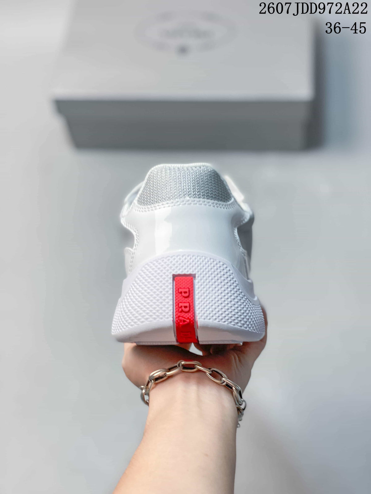 Rear view of the white sneaker showing the textured heel area and red vertical heel accent.