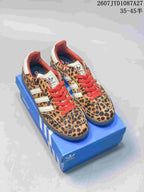 Pair of leopard-print adidas Samba ADV sneakers with red laces displayed on a blue adidas shoe box; size range text is visible at the top.