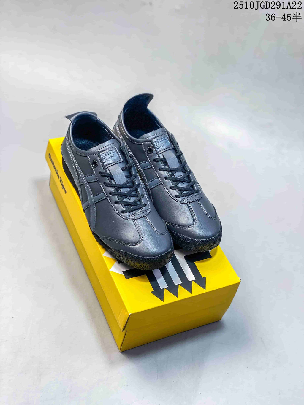 Pair of black Onitsuka Tiger low-top sneakers displayed on a yellow shoebox, with style code 2510JGD291A22 and a size range visible above.