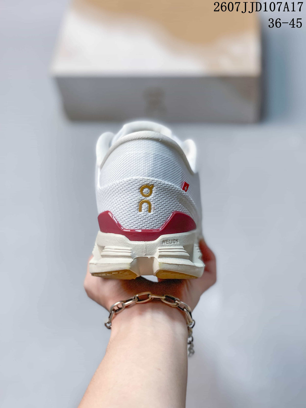 Rear view showing the padded heel, gold On branding, red heel detail, and outsole structure.