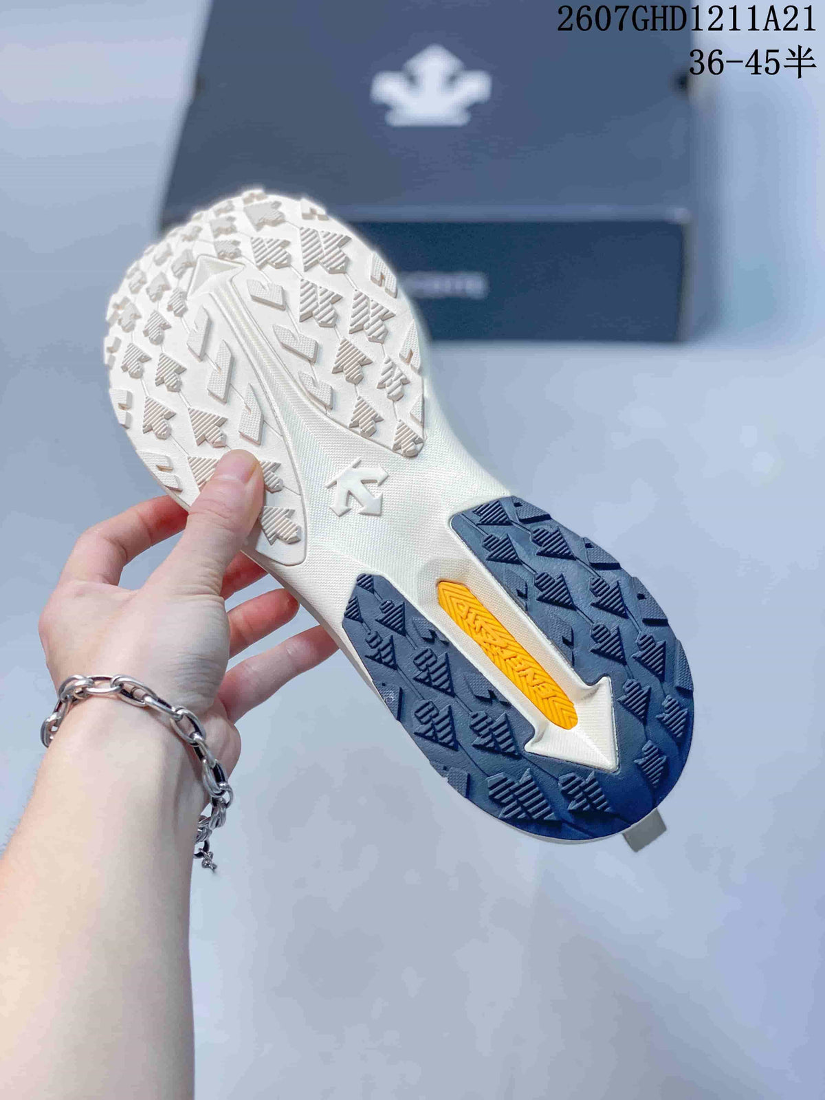 Underside of the sneaker showing a textured outsole with white, navy, and yellow sections.