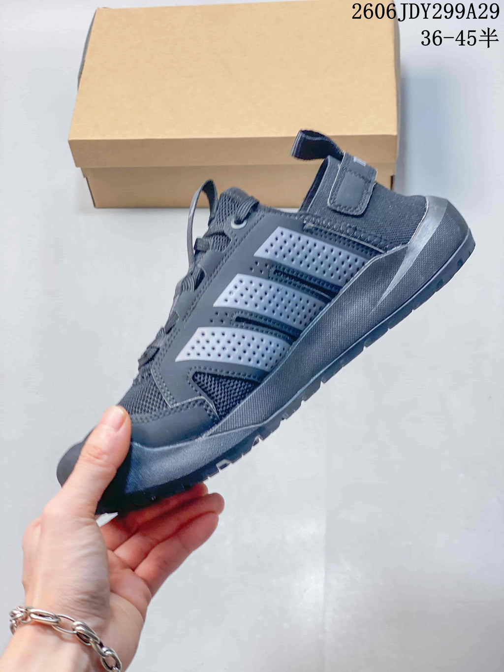 Side view of the dark gray sneaker showing the mesh upper, layered perforated side panels, lace system, and rugged sole.