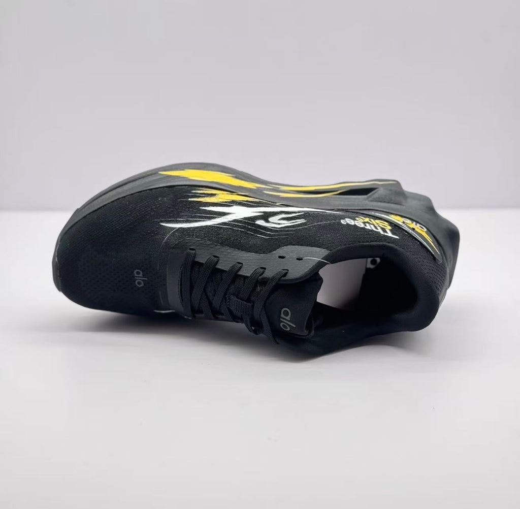 Angled top view highlighting the black upper, laces, tongue branding and side graphics.