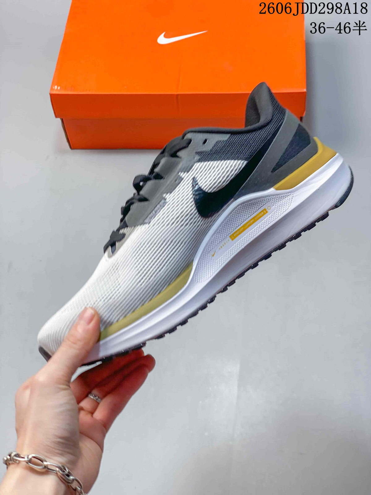 Side profile of the Nike sneaker showing the knit upper, Swoosh branding, gold accents and cushioned midsole.