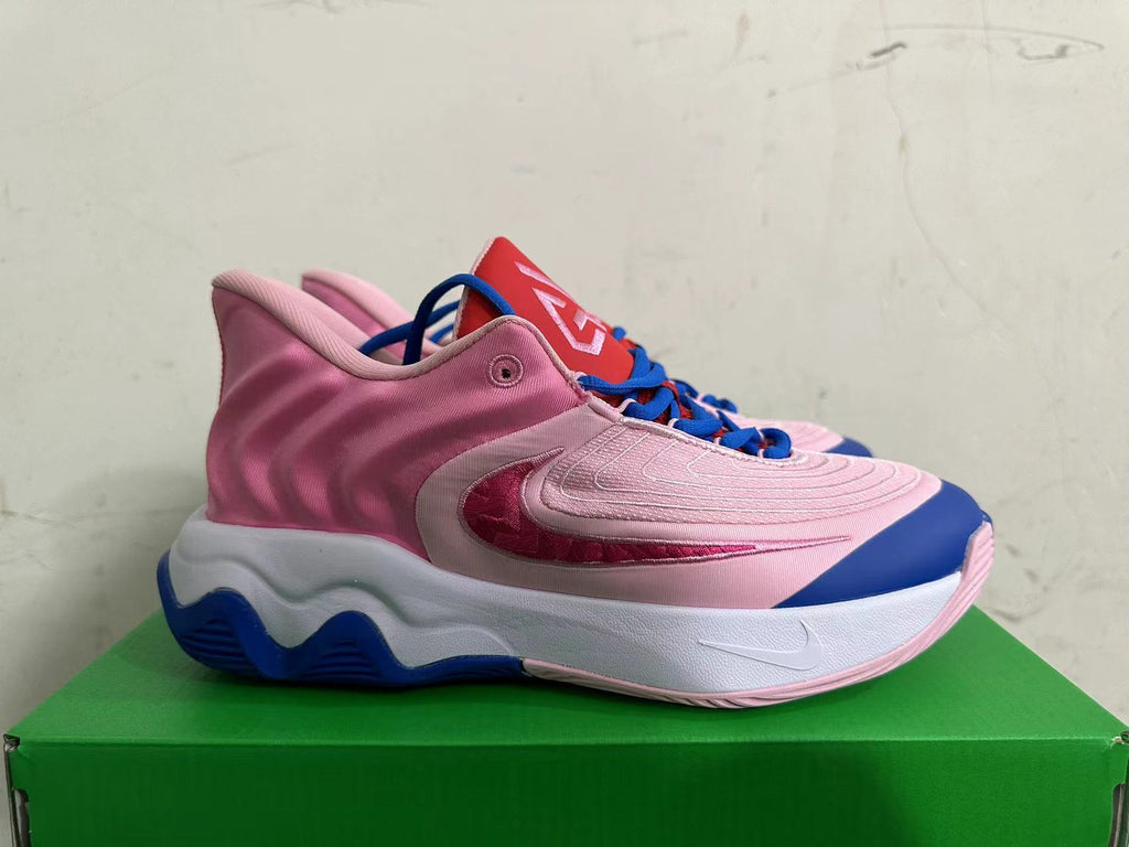 Side profile of a pink Nike basketball shoe with a sculpted white midsole and blue outsole.