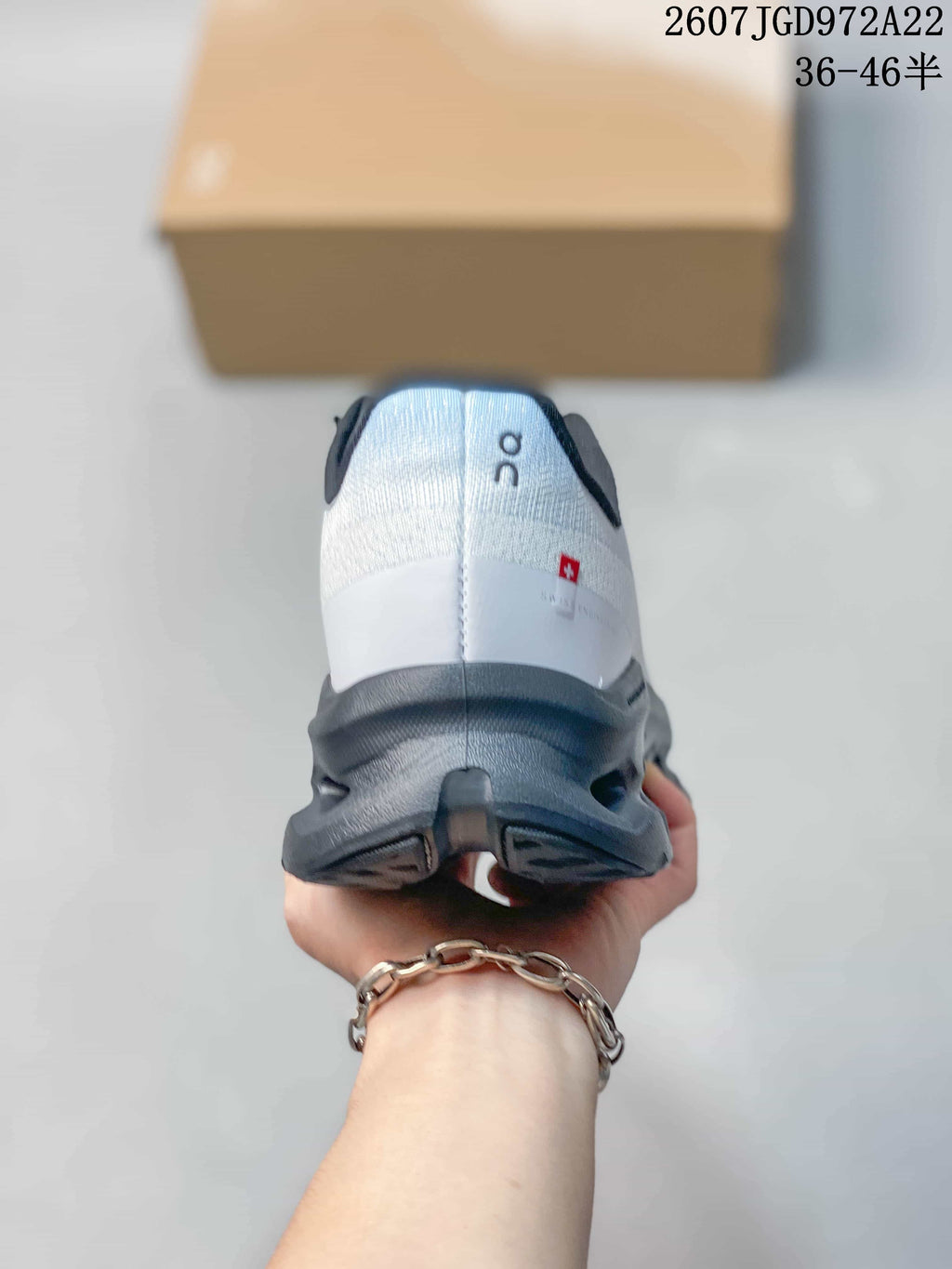 Rear view showing the white heel, On branding, dark collar, and red side detail.