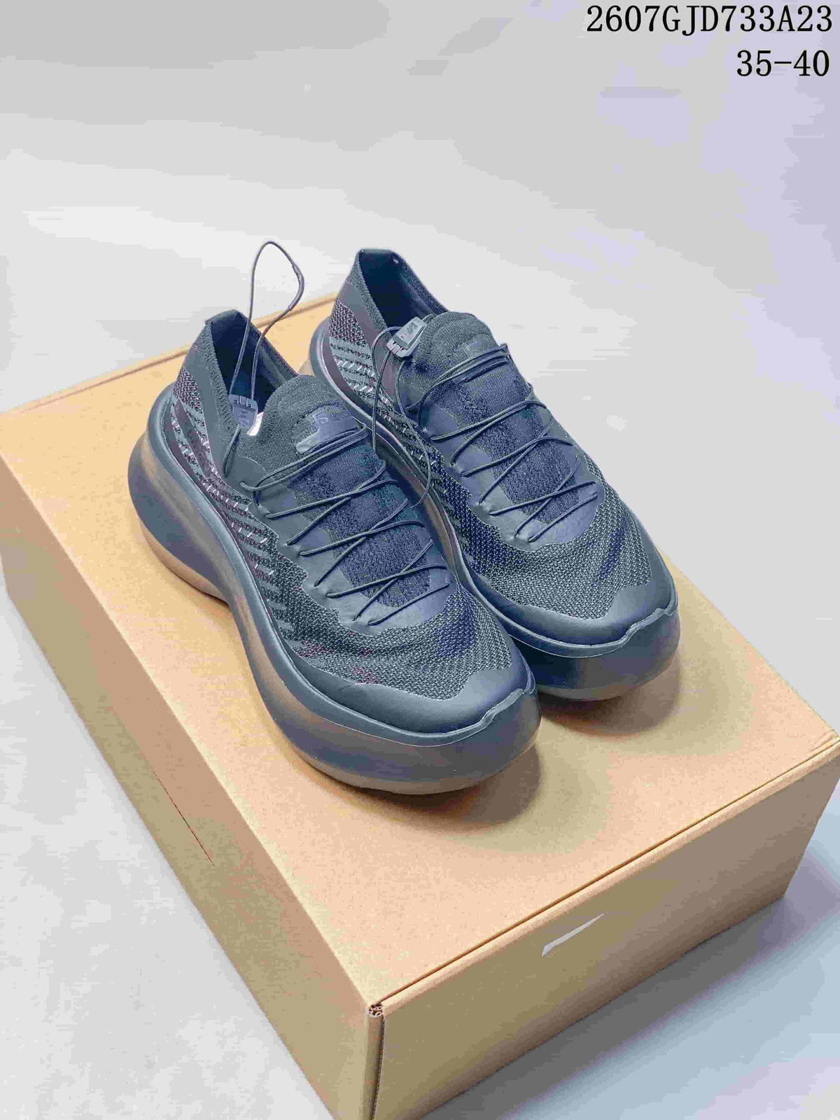 Pair of black Salomon-style low-top sneakers displayed on a tan box, with the listed range 35–40 visible above.