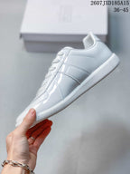 Side view of the white sneaker showing the paneled upper and tonal detailing