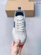 Top view of the white perforated sneaker with braided laces, blue accents, and rounded toe.